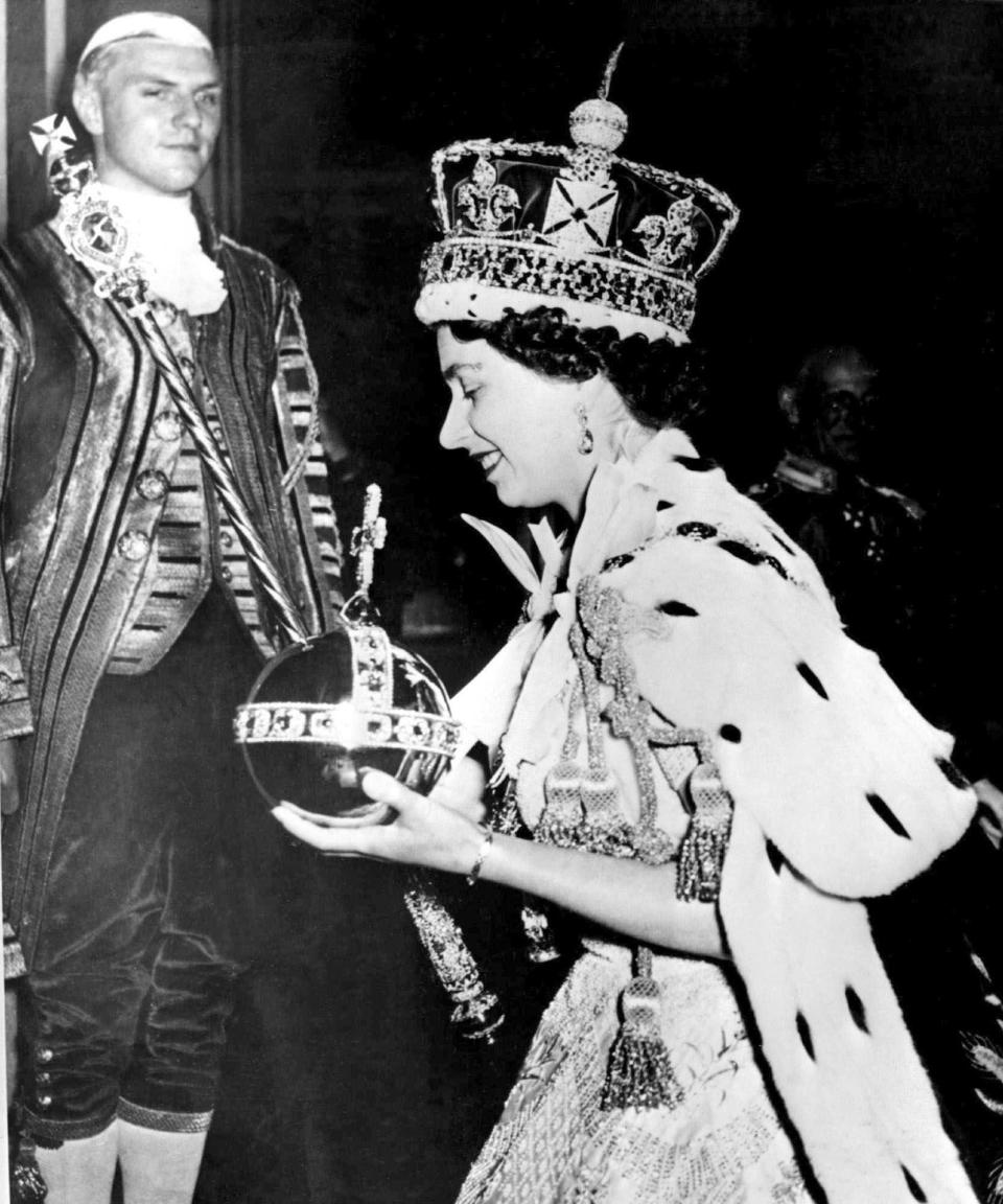 Queen Elizabeth II can be seen carrying the sovereign orb and scepter with cross while wearing the Imperial Crown during her coronation.