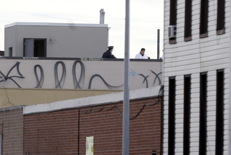 Police officers and crime scene personnel work on the roof of a building in the Brooklyn section of New York, Monday, Nov. 11, 2013. A musician shot and killed two members of an Iranian indie rock band, the Yellow Dogs, and a third musician early Monday, and wounded a fourth person at their apartment before killing himself on the roof, police and the group's manager said. The shooter was a member of another band from Iran, the Free Keys, who knew the victims but hadn't spoken to them in months because of a "petty conflict," according to Yellow Dogs manger Ali Salehezadeh. (AP Photo/Seth Wenig)