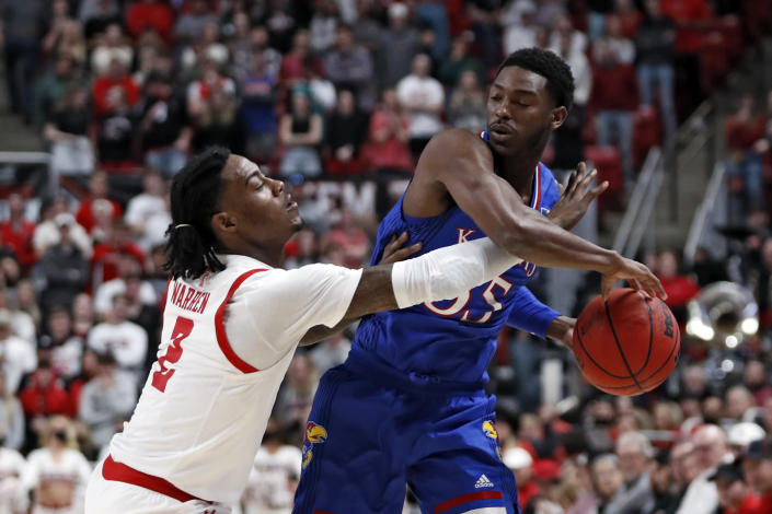 Kansas' Jalen Coleman-Lands (55) tries to pass the ball around Texas Tech's Davion Warren (2) during the first half of an NCAA college basketball game on Saturday, Jan. 8, 2022, in Lubbock, Texas. (AP Photo/Brad Tollefson)
