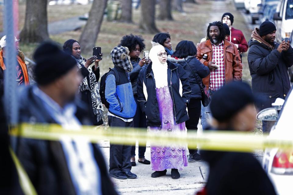 People view the Delaware Valley Charter School Friday, Jan. 17, 2014, in Philadelphia after two students were shot by another student. A boy hanging out in the high school gym with fellow students on Friday afternoon shot and wounded two of them before fleeing and being captured near his home, police said. A male student and a female student were shot, each in an arm. The wounded students were taken to a hospital near the school, where they were listed in stable condition, police said. (AP Photo/Matt Rourke)