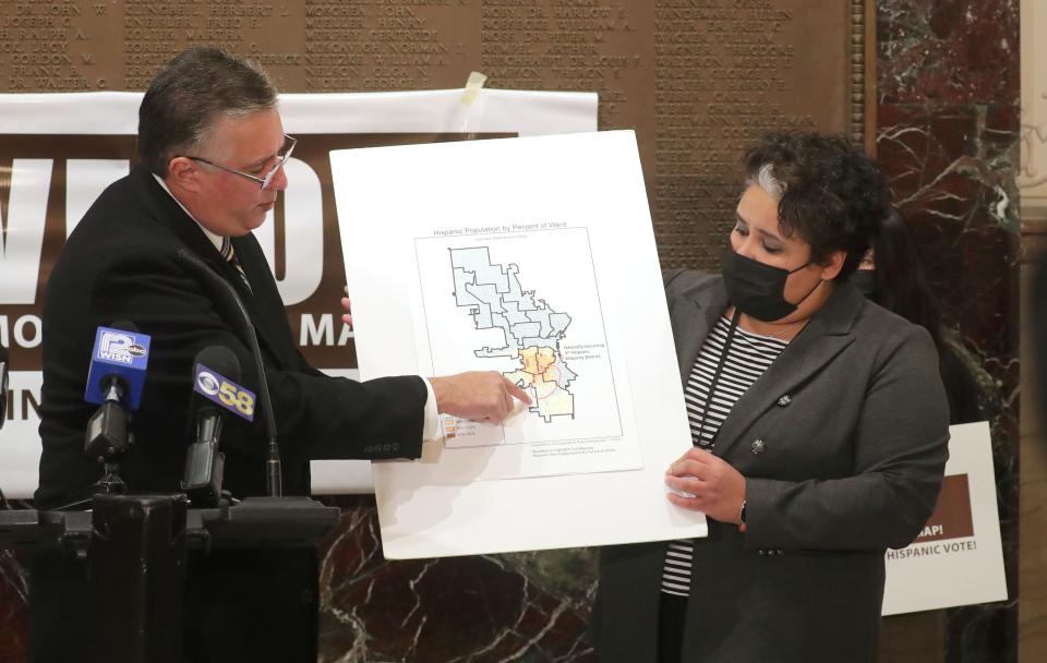 Darryl Morin, left, the national president with Forward Latino, points to a map marking the Hispanic population by percentage of ward as District 8 Ald. JoCasta Zamarripa holds the other side, during a press conference by Hispanic community leaders urging Milwaukee Mayor Tom Barrett to veto the redistricting map recently approved by the Milwaukee Common Council. They argue the map dilutes the Hispanic vote.