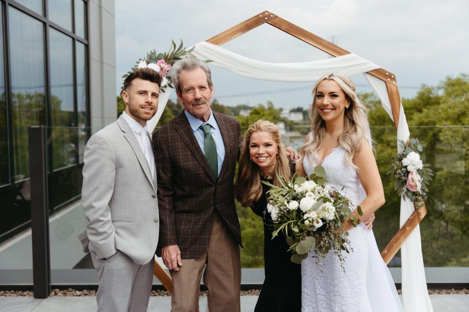 Couple on their wedding day with the parents of the bride