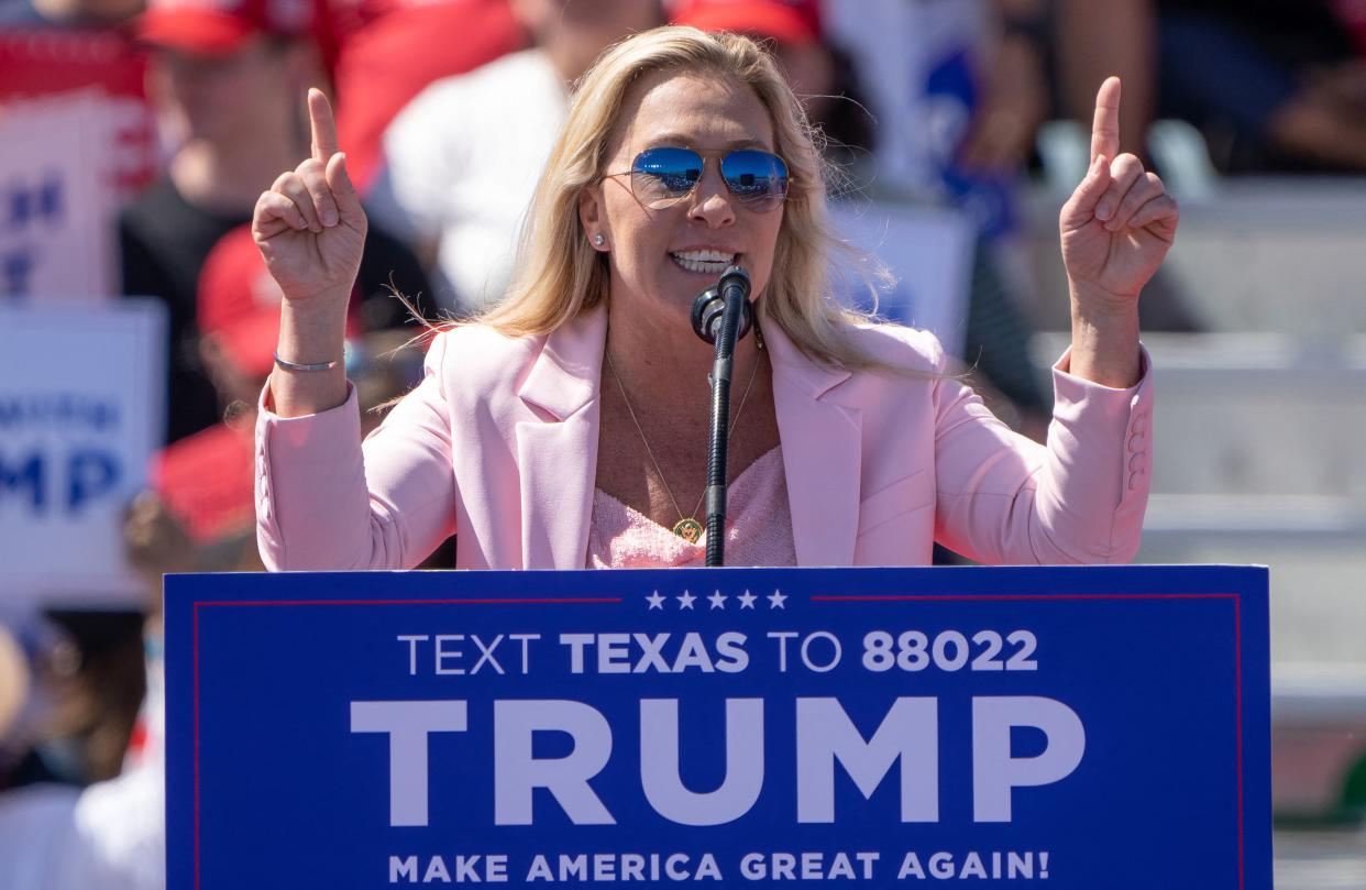 Rep. Marjorie Taylor Greene speaks from a podium at a 2024 campaign rally for former President Donald Trump.