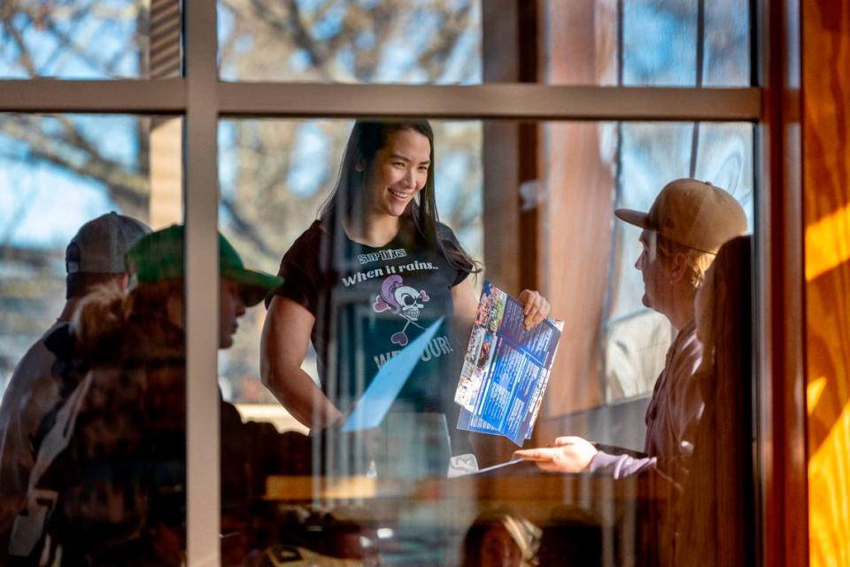 Natalie Broder, a bartender, server at Sup Dogs takes an order from a table of customers during her shift on Sunday, February 4, 2024 in Greenville, N.C.  Broder is one of several Sup Dogs employees that been participants in MrBeast videos.