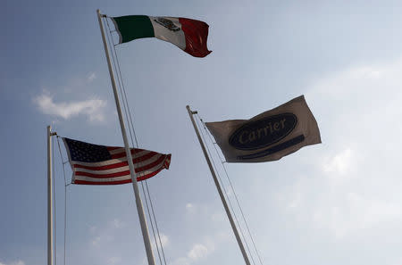 The flags of U.S., Mexico and Carrier flies on a pole at the Carrier Corp air conditioner plant, a unit of United Technologies Corp, in Santa Catarina, on the outskirts of Monterrey, Mexico, February 17, 2016. REUTERS/Daniel Becerril