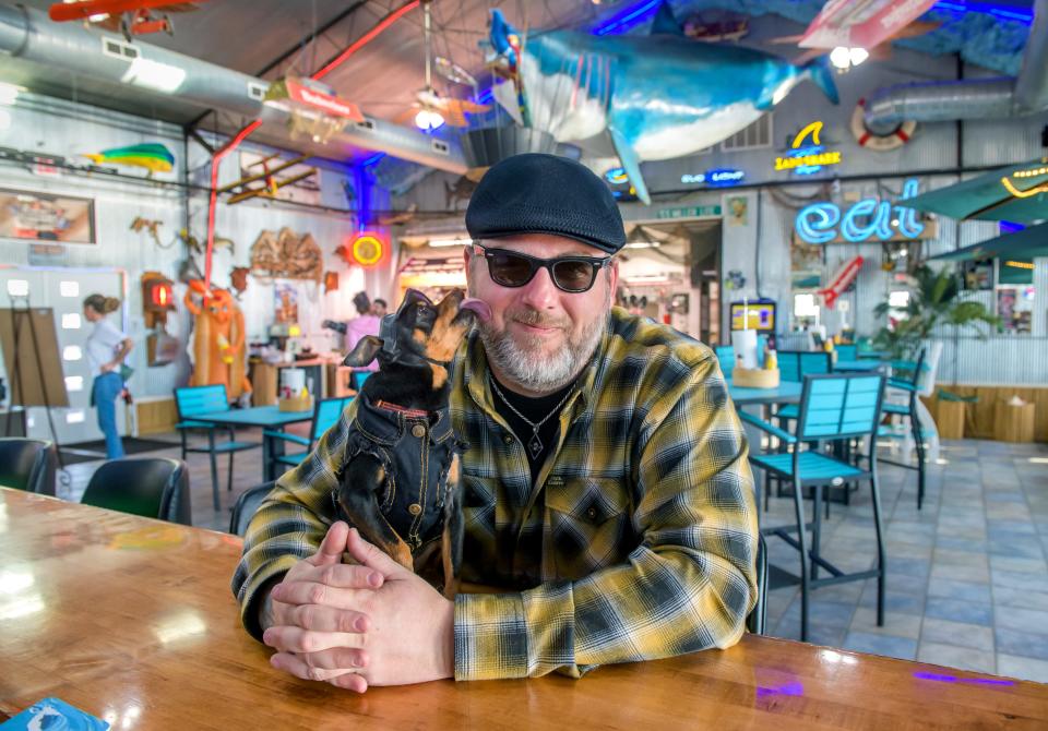 Charlie, a 9-year-old mini-pinscher, gives Chris Stewart a little affection at their new restaurant Charlie's at Sunset Cove, 1111 Sunset Driver off Spring Bay Road in East Peoria. Stewart opened the business on Feb. 1 after an extensive renovation of a previous eatery called Dolphin Cove.