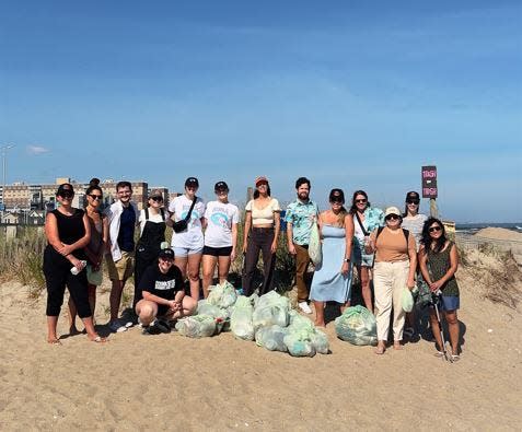 During the second stop on their 'Catch a Clean Wave' tour in Rockaway Beach, N.Y., Anna Gudauskas (center), Sarah Lee (taking picture) and dozens of volunteers cleaned the beach.