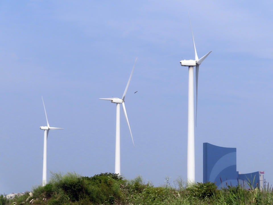 FILE - Land-based wind turbines in Atlantic City, N.J., turn on July 20, 2023. Two major offshore wind power projects are taking steps forward in New Jersey as the owners of one project agreed to bring the federal government in on their environmental monitoring plans at an earlier stage than has ever been done, and federal regulators said plans for another project are not expected to kill or seriously injure marine life. They come as New Jersey continues to grow as a hub of opposition to offshore wind projects from residents' groups and their political allies, mostly Republicans. (AP Photo/Wayne Parry, File)