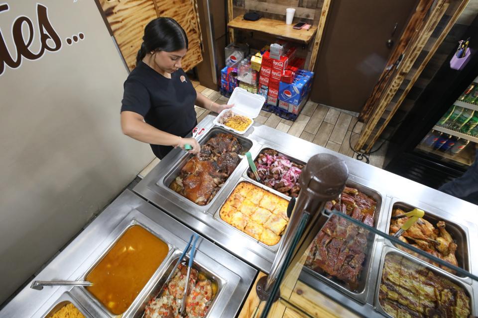 Kimberly Moctezuma serves up pork shoulder on a bed of yellow rice during the lunch hour at Casa Campo on E. Main St. in Rochester Tuesday, Aug. 1, 2023.  