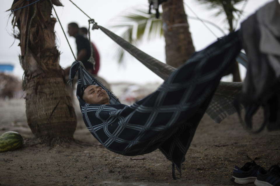 A migrant sleeps on a hammock on the beach in Necocli, Colombia, waiting to board a boat to cross the Uraba Gulf and walk across the Darien Gap to Panama in the hope of reaching the US, on Sunday, May 7, 2023. (AP Photo/Ivan Valencia)