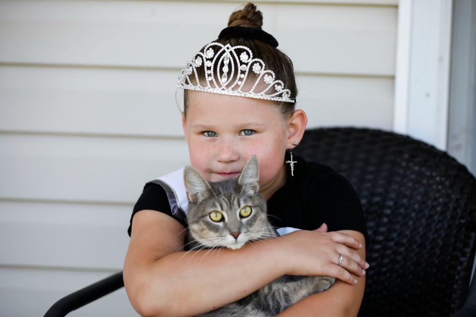 Six-year-old Bentlee Graham holds her cat Kiki who made it out of the family's home during a house fire on Friday, Aug. 4, 2023.