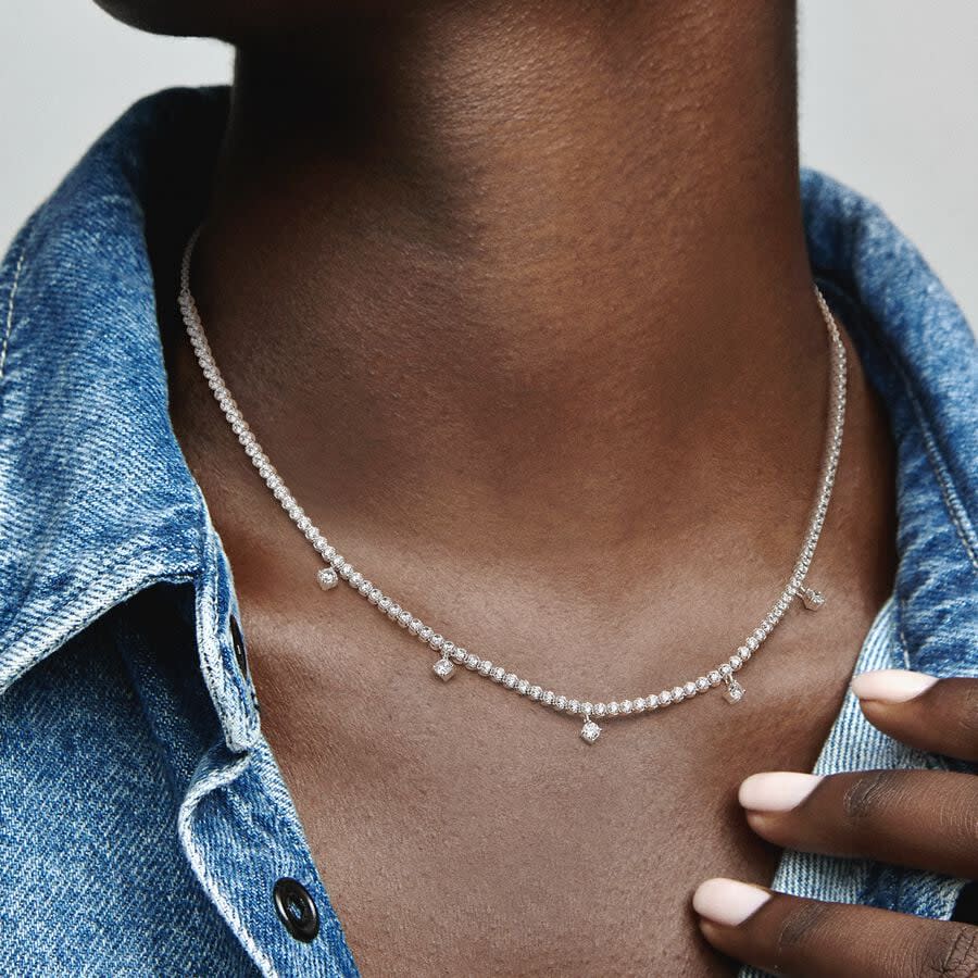 model wearing diamond drop necklace with denim top