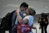 Karen Tyler greets and kisses her son Jonathan, who she's not seen for over a year and a half as he arrives on a flight from Houston, Texas, in the U.S., at Terminal 5 of Heathrow Airport in London, Monday, Aug. 2, 2021. Travelers fully vaccinated against coronavirus from the United States and much of Europe were able to enter Britain without quarantining starting today, a move welcomed by Britain's ailing travel industry. (AP Photo/Matt Dunham)