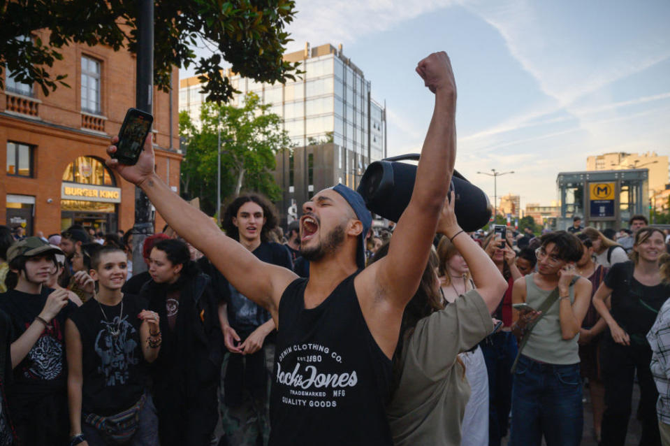 People celebrate after the first results of the second round of France's legislative election Sunday. 