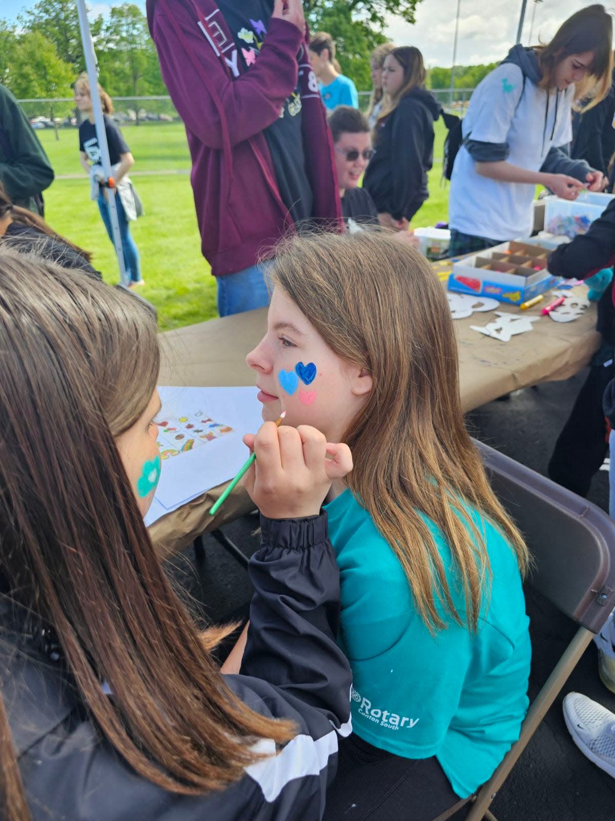 Sandy Valley sixth grader Cambrya Calkins, 12, gets her face painted by Perry High School freshman Layla Wickham on Friday during the Exceptional Olympics held at Perry. About 750 students from 22 school districts participated in the games.