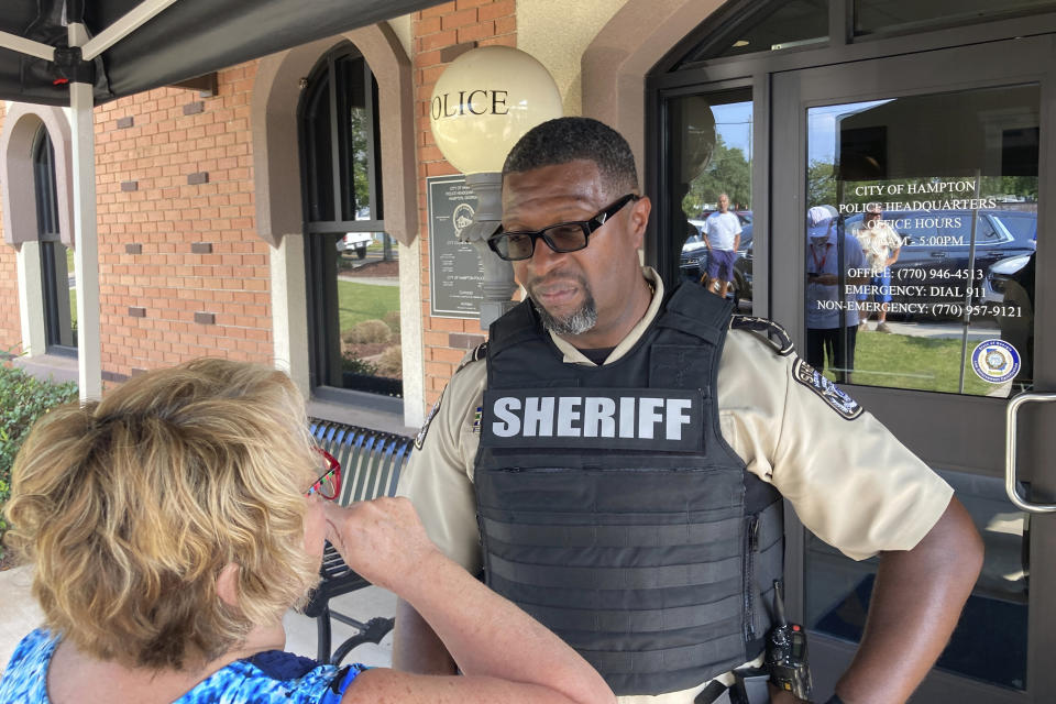 Henry County Sheriff Reginald Scandrett talks to a local resident on Sunday, July 16, 2023, in Hampton, Ga. Scandrett and other law enforcement officials announced that officers shot and killed Andre Longmore on Sunday, a day after officials say Longmore shot and killed four Hampton residents. (AP Photo/Jeff Amy)