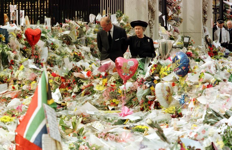 FILE PHOTO: Queen Elizabeth II and Duke of Edinburgh look at the mass of floral tributes laid outside Buckingha..