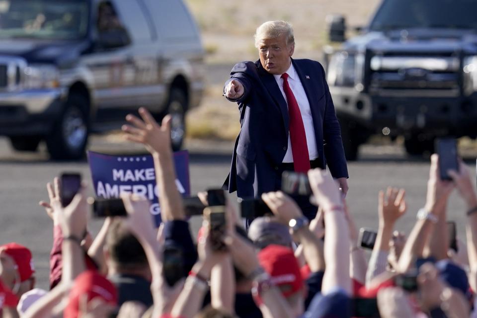 President Donald Trump waves to a cheering crowd as he arrives for a campaign rally Monday, Oct. 19, 2020, in Tucson, Ariz. (AP Photo/Ross D. Franklin)