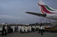 Sri Lankan air port workers carry remains of Priyantha Kumara, a Sri Lankan employee who was lynched by a Muslim mob in Sialkot last week after unloading it from an aircraft in Colombo, Sri Lanka, Monday, Dec. 6, 2021. (AP Photo/Eranga Jayawardena)