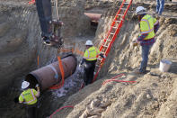 In this April 13, 2020, photo provided by TC Energy, construction contractors for TC Energy are seen installing a section of the Keystone XL crude oil pipeline at the U.S.-Canada border north of Glasgow, Mont. U.S. District Judge Brian Morris has struck down a nationwide permitting program for new oil and gas pipelines in a lawsuit against the controversial Keystone XL oil sands pipeline from Canada. (TC Energy via AP)