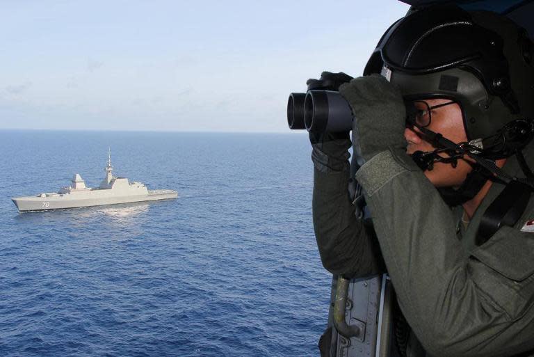 A Singapore Navy photo shows personnel participating in the search and rescue operations in the South China Sea for the missing Malaysia Airlines flight MH370, on March 13, 2014