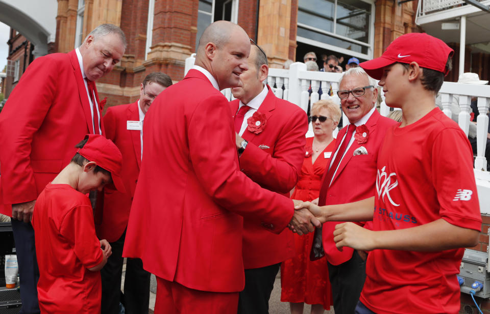 Former England cricketer Andrew Strauss, centre, is surrounded by people wearing red as Lord's cricket ground is turned red in aid of the Ruth Strauss Foundation, ahead of the second day of the second Ashes test match between England and Australia at Lord's cricket ground in London, Thursday, Aug. 15, 2019. The Ruth Strauss Foundation was set up by former England cricketer Andrew Strauss in honour of his wife Ruth, who died from a rare form of lung cancer in December 2018. (AP Photo/Frank Augstein)