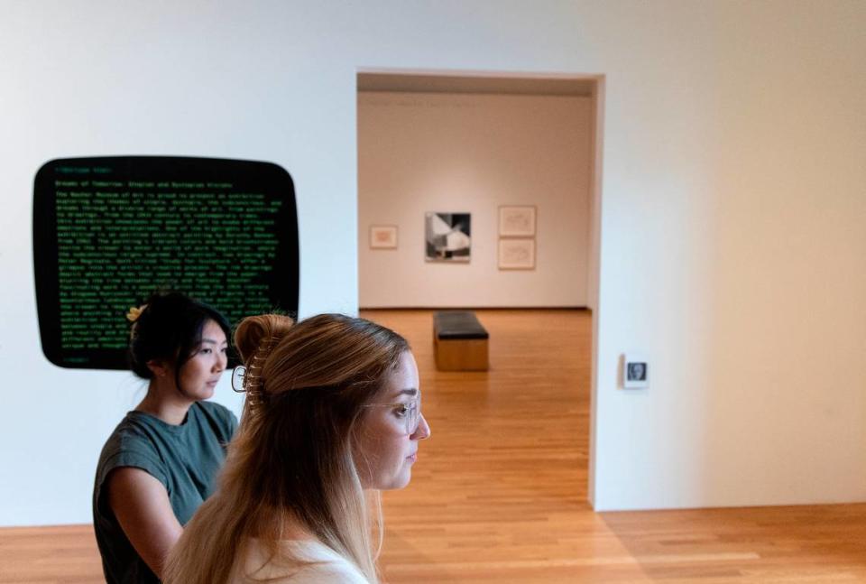 Julianne Miao, curatorial assistant, and Julia McHugh, curator and director of academic initiatives, stand at the entrance to an exhibit curated by A.I. at the Nasher Museum of Art at Duke University on Thursday, Sept. 14, 2023, in Durham, N.C.