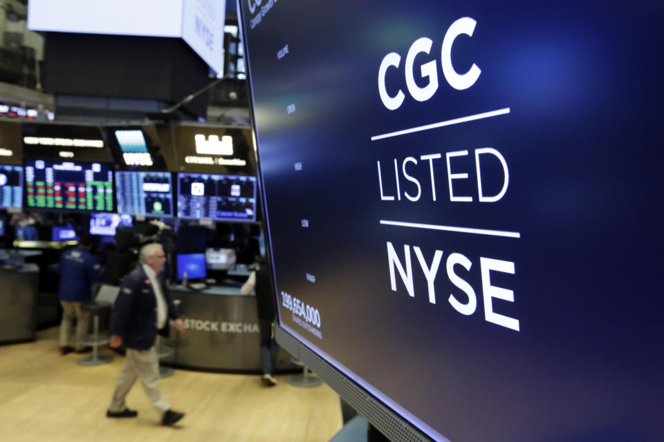 FILE- In this May 31, 2018, file photo the logo for Canada's Canopy Growth Corp. appears on a screen above a trading post on the floor of the New York Stock Exchange. Investors are craving marijuana stocks as Canada prepares to legalize pot next month, leading to giant gains for Canada-based companies listed on U.S. exchanges. (AP Photo/Richard Drew, File)