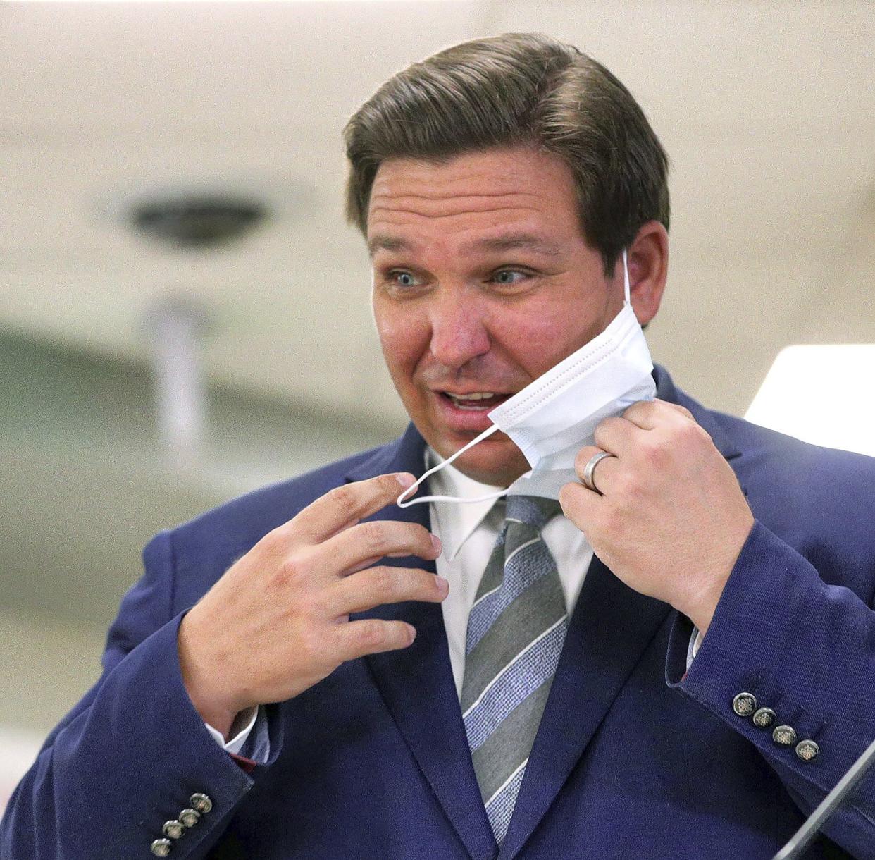 Florida Gov. Ron DeSantis removes his mask to answer questions during a press conference at Orlando Health South Seminole Hospital in Longwood, Fla., Monday, Jan. 4. 