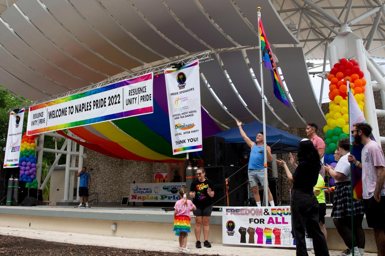 People react after the pride flag is raised during the 4th Annual Naples Pride Fest, Saturday, July 9, 2022, at Cambier Park in Naples, Fla.