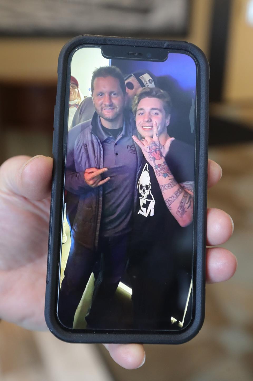 Donnie Boyer, owner of Pick's at Portage Lakes, shows a cellphone photo of himself, left, and Sebastian Spencer, who died in an ATV accident in February 2021.