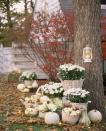 <p>Spooky black-and-orange decorations aren't your thing? Try this pretty alternative: Place white chrysanthemums and ornamental cabbage in cream-colored apple baskets on your front lawn, and surround with white pumpkins and gourds. (Note: For a similar look minus the danger, lanterns and jack-o'-lanterns should always be lit with battery-operated lights, like these LED votives.) </p>