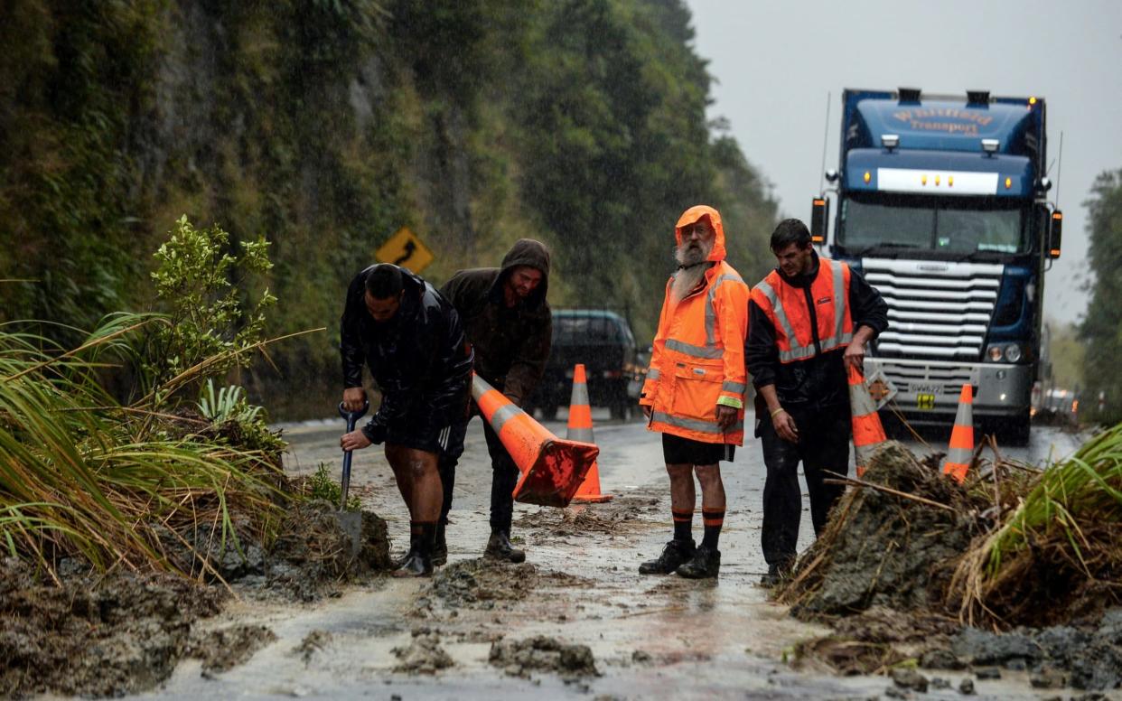 A landslide caused by rains from ex-Cyclone Debbie is shoveled off a main road between Napier and Taupo in the North Island of New Zealand - REUTERS