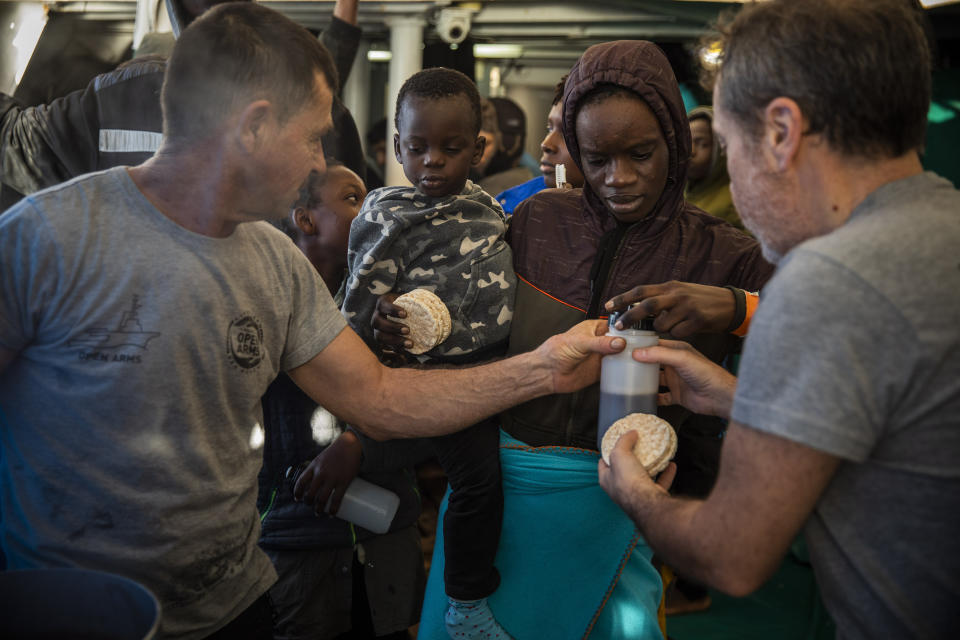 Fatoumata and her 2-year-old son Madou, receive breakfast from aid workers aboard the from the Spanish NGO Open Arms rescue vessel, as the NGO waits for the authorities to allow them to enter in the nearest safe port with the 118 people rescued on Friday off the Libyan coast, international waters, Central Mediterranean sea, next to the Italian island of Lampedusa, Tuesday Jan. 14, 2020. (AP Photo/Santi Palacios)