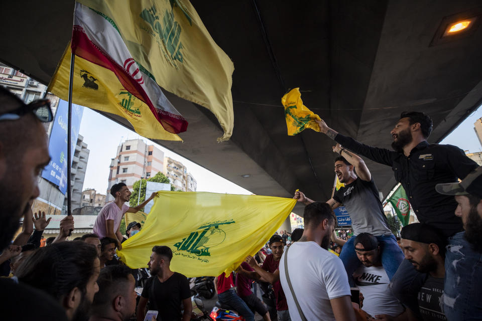 Hezbollah and Amal supporters wave Hezbollah and Iranian flags as they shout slogans against Israel and U.S. during a protest in the southern suburb of Beirut, Lebanon, Sunday, June 28, 2020. The protest came hours after Lebanon's foreign minister summoned the U.S. ambassador to Beirut over comments, she made recently in which she criticized Hezbollah. The meeting between Foreign Minister Nassif Hitti and Ambassador Dorothy Shea is scheduled for Monday afternoon. (AP Photo/Hassan Ammar)