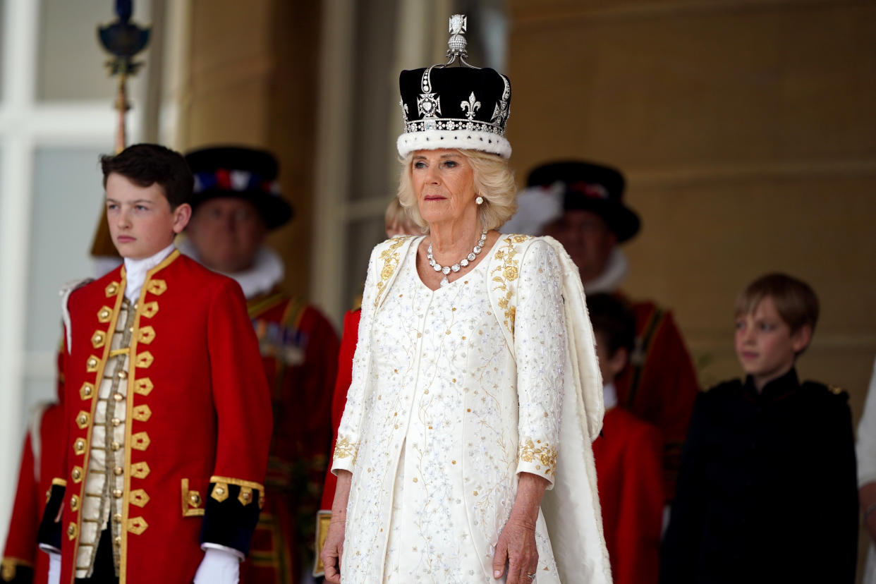 Queen Camilla receives a royal salute from members of the military in the gardens of Buckingham Palace