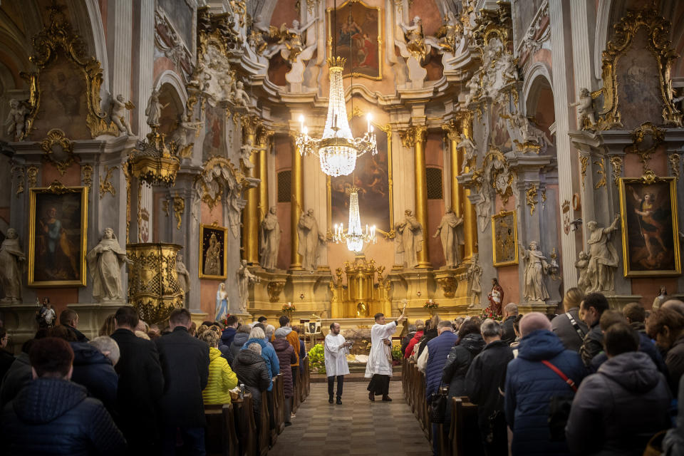A priest blesses the congregations during an Easter service, at the Church of St Theresa in Vilnius, Lithuania, Saturday, April 8, 2023. (AP Photo/Mindaugas Kulbis)