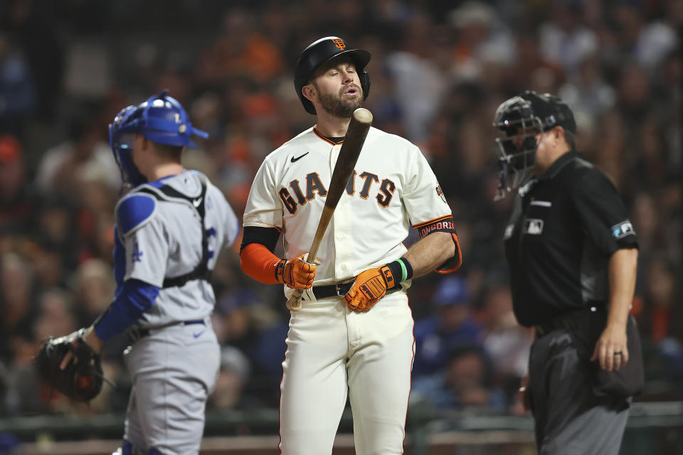 San Francisco Giants' Evan Longoria, middle, reacts after striking out against the Los Angeles Dodgers during the seventh inning of Game 5 of a baseball National League Division Series Thursday, Oct. 14, 2021, in San Francisco. (AP Photo/John Hefti)