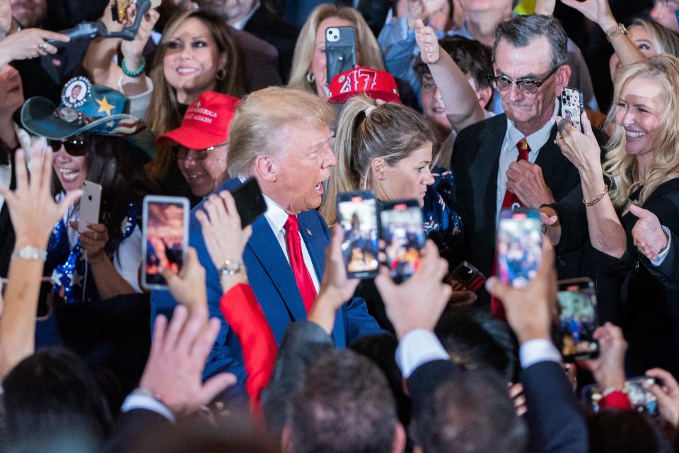 Former President Donald Trump greets supporters as he arrives at Mar-A-Lago on Tuesday, April 4, 2023, in Palm Beach.