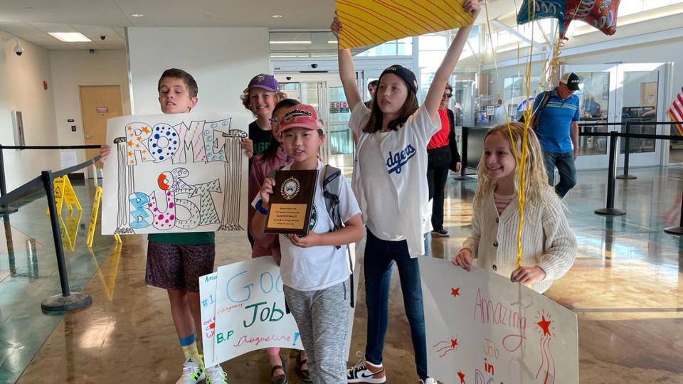 Augustine Zhao, center, holds the plaque he won at the National History Bee finals in Washington, D.C., surrounded by his Bishop’s Peak Elementary School classmates when he returned to the San Luis Obispo County Regional Airport in June 2023.