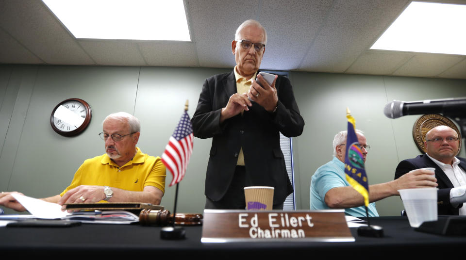 Board of County Commissioners chairman Ed Eilert checks his cell phone following the Johnson County Board of Canvassers meeting, Monday, Aug. 13, 2018, in Olathe, Kan. County election officials across Kansas on Monday began deciding which provisional ballots from last week's primary election will count toward the final official vote totals, with possibility that they could create a new leader in the hotly contested Republican race for governor. Secretary of State Kris Kobach led Gov. Jeff Colyer by a mere 110 votes out of more than 313,000 cast as of Friday evening. (AP Photo/Charlie Neibergall)