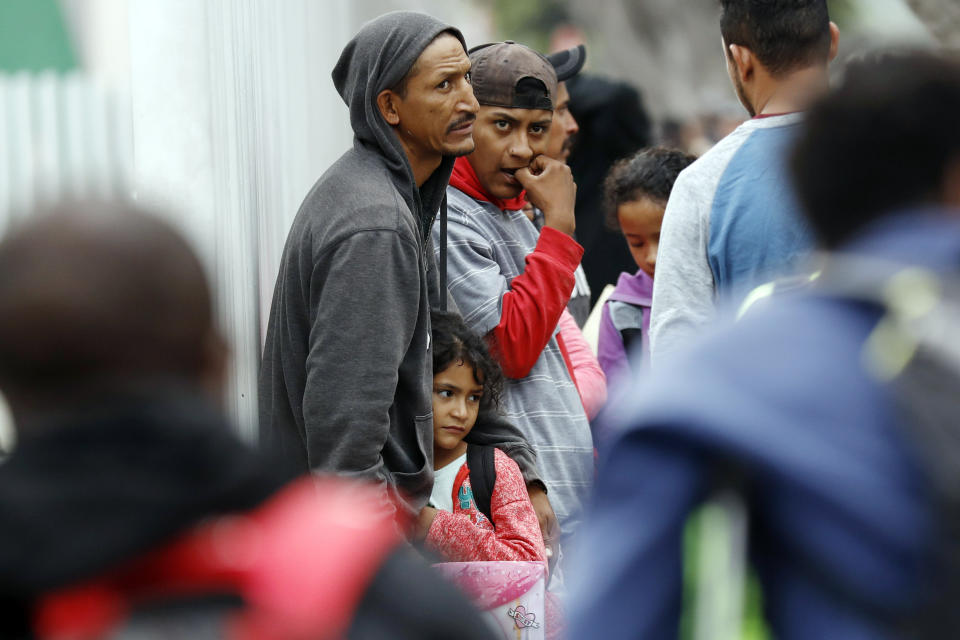 FILE - In this July 16, 2019 file photo, people wait to apply for asylum in the United States along the border in Tijuana, Mexico. The American Civil Liberties Union said Tuesday, July 30, 2019 that more than 900 children have been separated from their families at the border since a judge ordered last year that the practice be sharply curtailed. The ACLU says about one of every five children separated is under 5 years old. (AP Photo/Gregory Bull, File)