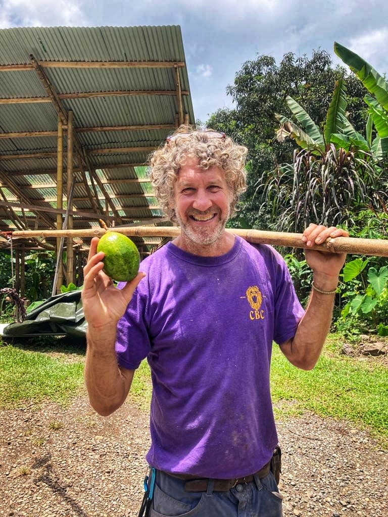 Tim O'Hara holding fruit at a family-run fruit and vegetable farm in Mastatal, Costa Rica.