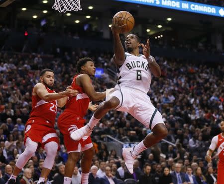 Jan 31, 2019; Toronto, Ontario, CAN; Milwaukee Bucks guard Eric Bledsoe (6) goes up to make a basket against Toronto Raptors guard Kyle Lowry (7) and guard Fred VanVleet (23) at Scotiabank Arena. Milwaukee Bucks defeated Toronto. Mandatory Credit: John E. Sokolowski-USA TODAY Sports