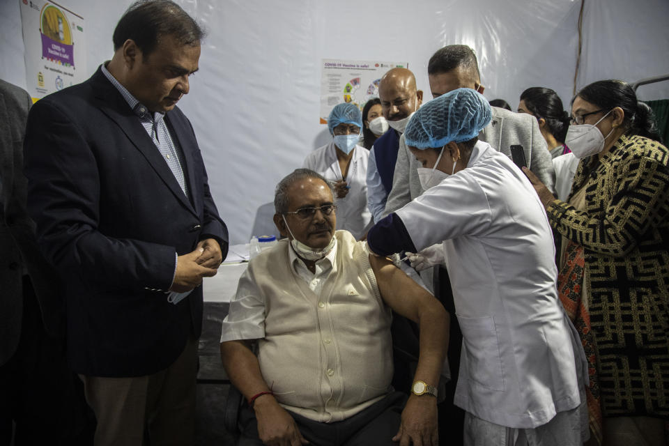 A doctor receives a COVID-19 vaccine as Health Minister of Assam state Himanta Biswa Sharma, left, looks on at a government Hospital in Gauhati, India, Saturday, Jan. 16, 2021. India started inoculating health workers Saturday in what is likely the world's largest COVID-19 vaccination campaign, joining the ranks of wealthier nations where the effort is already well underway. (AP Photo/Anupam Nath)