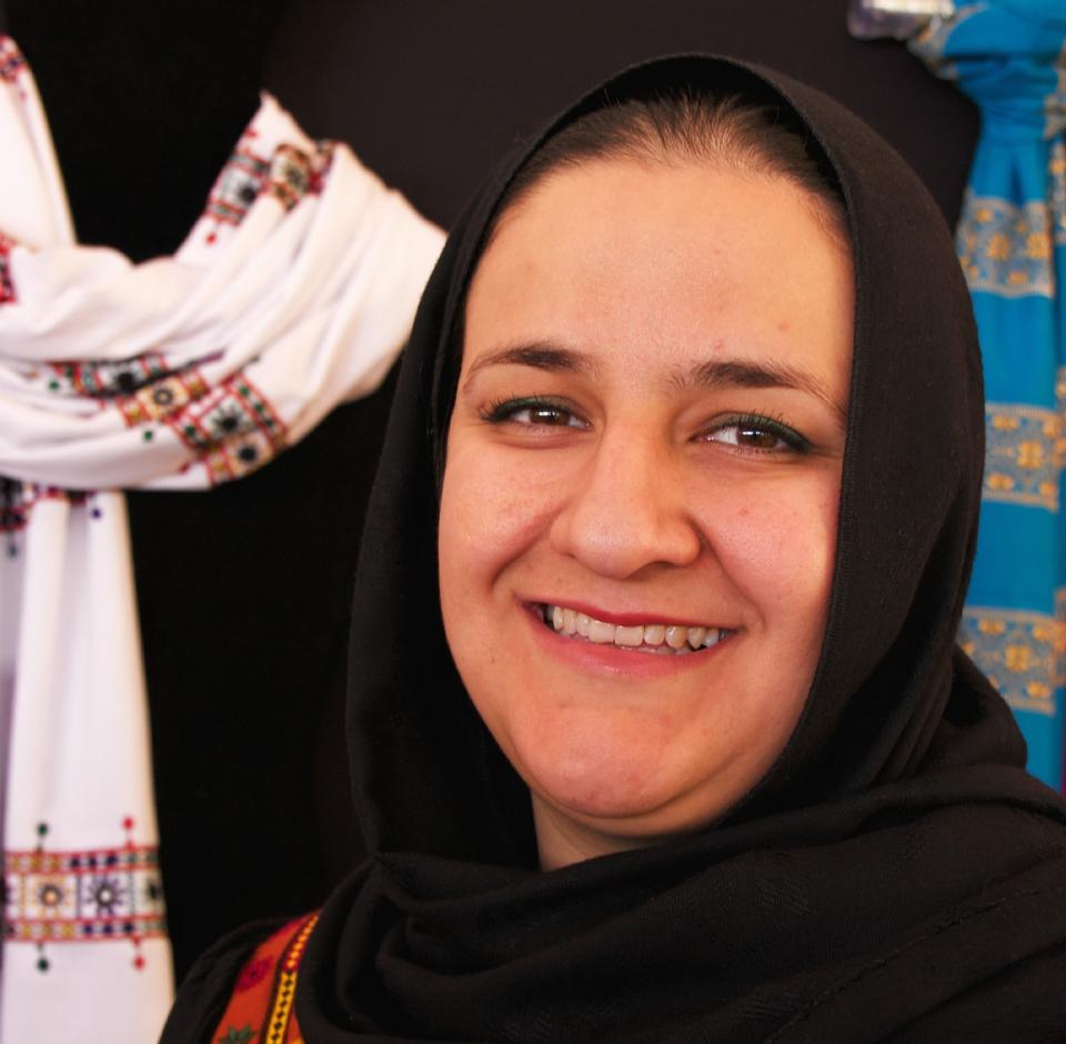 This undated photo provided by the Santa Fe International Folk Art Market shows Rangina Hamidi of Kandahar Treasure, a cooperative of Afghan women that sells products bearing traditional embroidery as a way to fight poverty. Hamidi will represent Kandahar Treasure at the annual market in Santa Fe, N.M., July 13-15. (AP Photo/Santa Fe International Folk Art Market, Judith Haden)