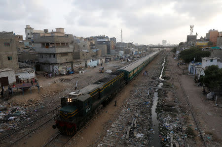 A passenger train moves along a neighbourhood in Karachi, Pakistan September 18, 2018. REUTERS/Akhtar Soomro