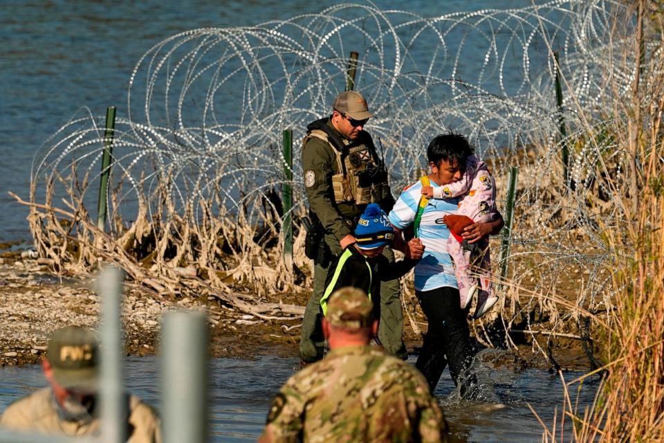 PHOTO: Migrants are taken into custody by officials at the Texas-Mexico border, Jan. 3, 2024, in Eagle Pass, Texas.  (Eric Gay/AP)