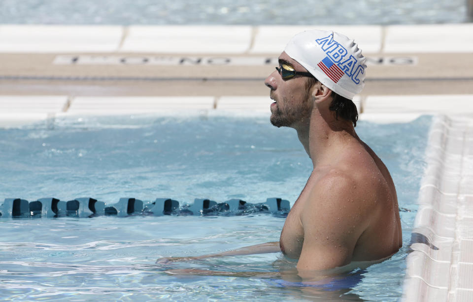 Michael Phelps warms up prior to competing in the 100-meter butterfly during the Arena Grand Prix, Thursday, April 24, 2014, in Mesa, Ariz. It is Phelps' first competitive event after a nearly two-year retirement. (AP Photo/Matt York)