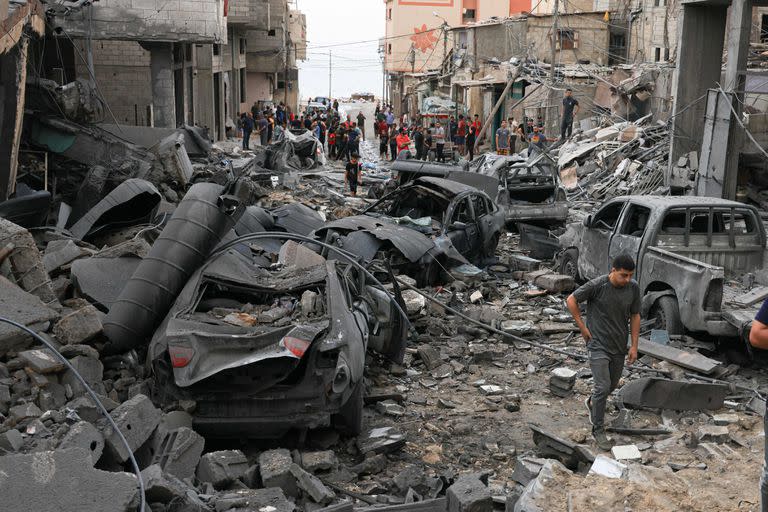 Los palestinos inspeccionan la destrucción en un barrio gravemente dañado por los ataques aéreos israelíes en la ciudad de Gaza a principios del 9 de octubre de 2023